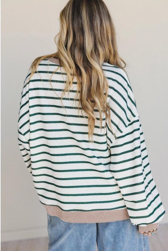 Back of model wearing a green and white striped crewneck and neutral background