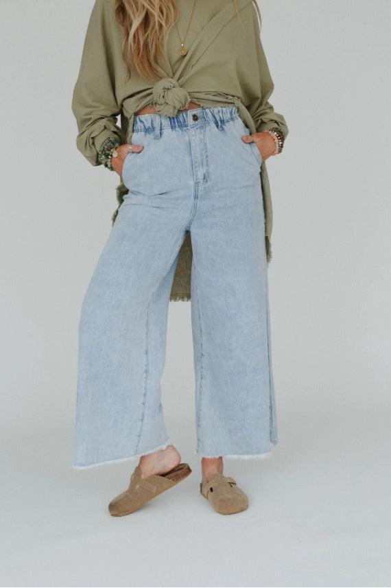 Model wearing light wide leg blue jeans